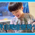 絵の具のついた服を着た子どもが笑顔で活動している世界自閉症啓発デーの画像