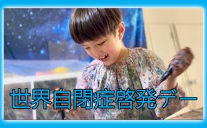 絵の具のついた服を着た子どもが笑顔で活動している世界自閉症啓発デーの画像