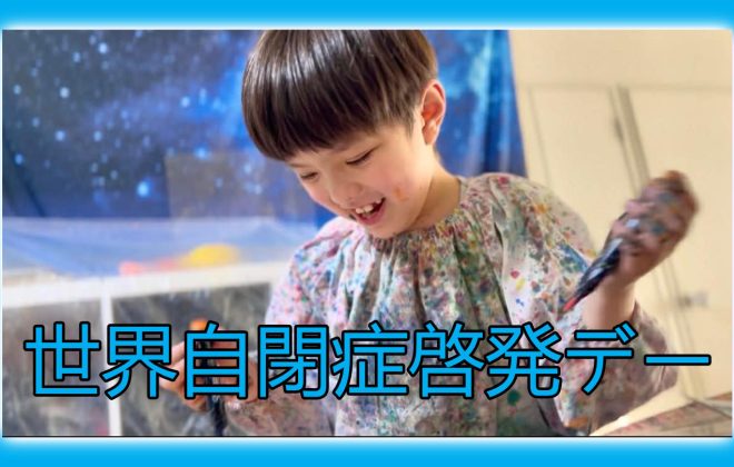 絵の具のついた服を着た子どもが笑顔で活動している世界自閉症啓発デーの画像